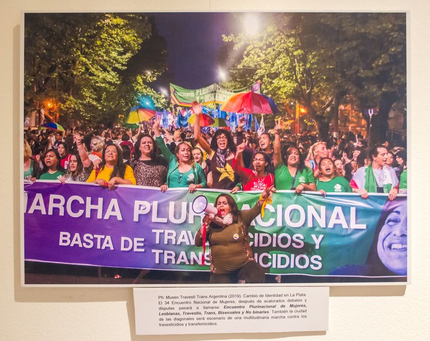 En las paredes de la sala Auditorio de la Comisión Permanente por la Memoria se encuentran colgadas imágenes de distintas luchas y momentos destacados para la comunidad Trans.