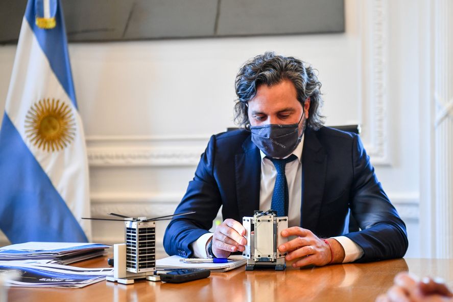 Santiago Cafiero junto al psico satélite que la Argentina lanzará al espacio