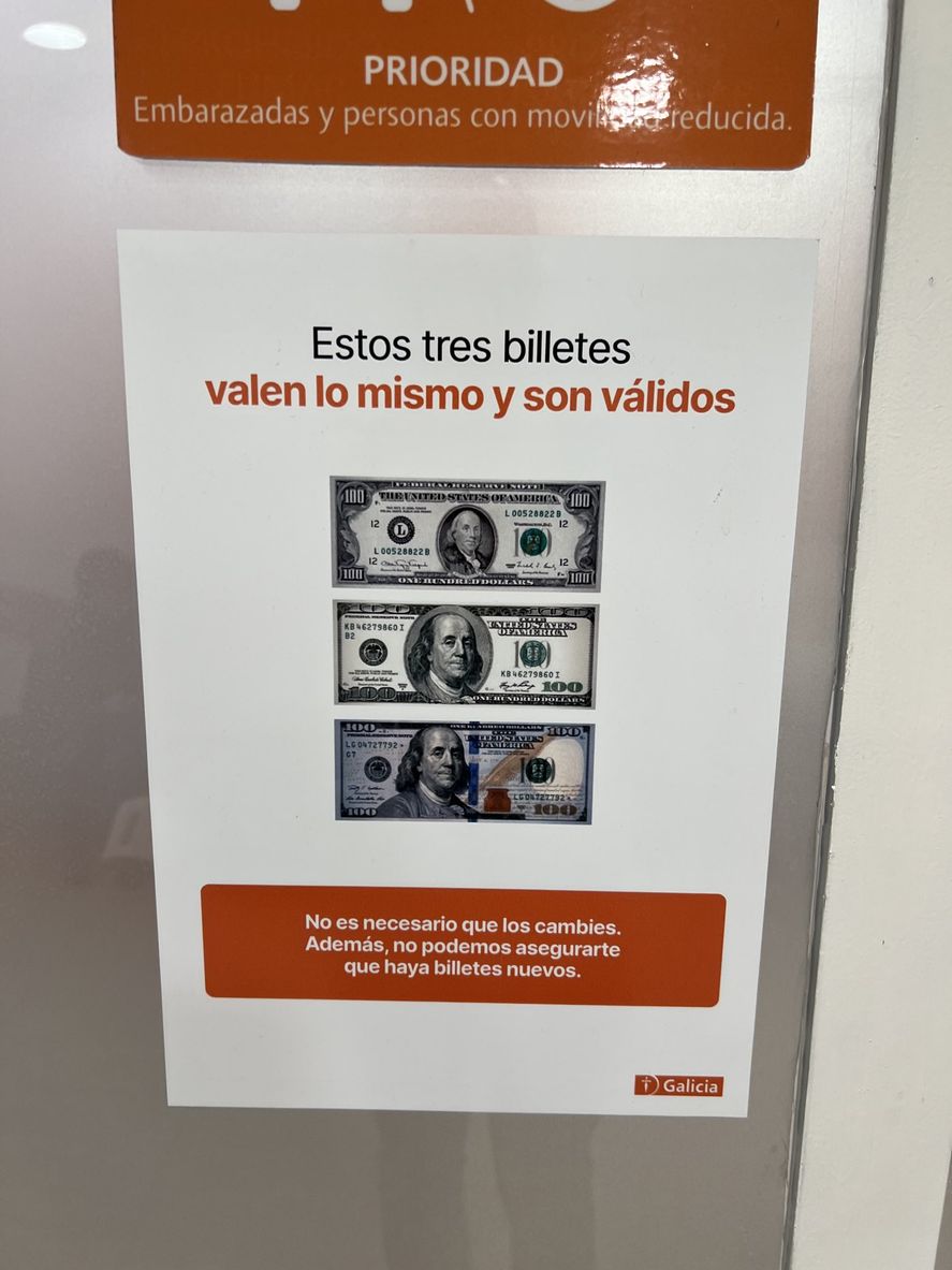 El cartel colocado en un banco argentino que expresa la igualdad de valor entre los diferentes billetes de dólares, ya sean de cabeza chica o grande.