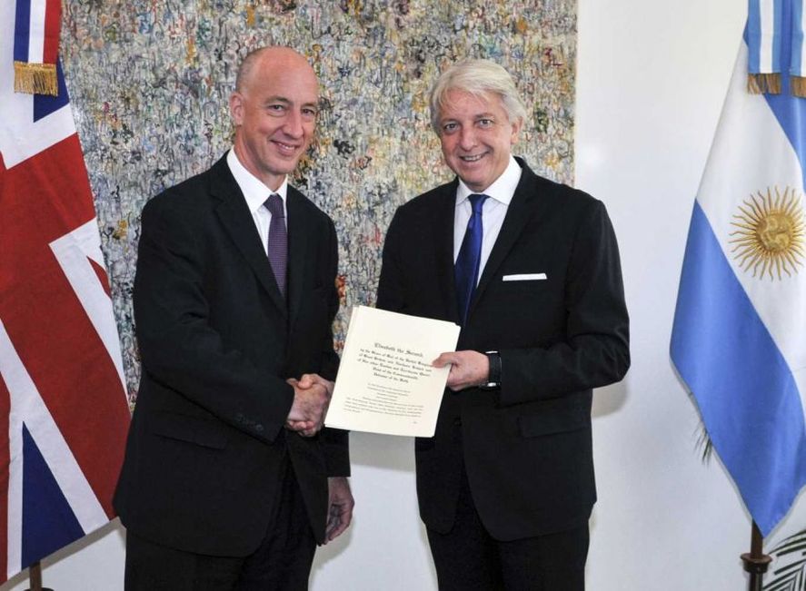 El embajador británico en Argentino, Mark Kent, estrecha la mano de Carlos Foradori.