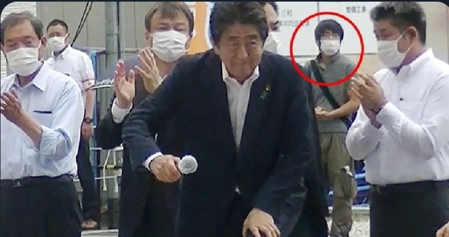 Está tremenda imagen muestra al ex Primer Ministro de Japón Shinzo Abe instantes antes de que se produjese el asesinato en manos de quién se ve al fondo de la escena, de chomba gris y pantalón caqui