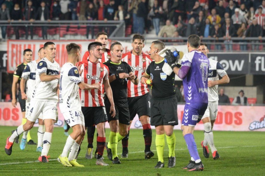 Rodrigo Rey al cruce de jugadores de Estudiantes y defensa de los de Gimnasia en el clásico platense