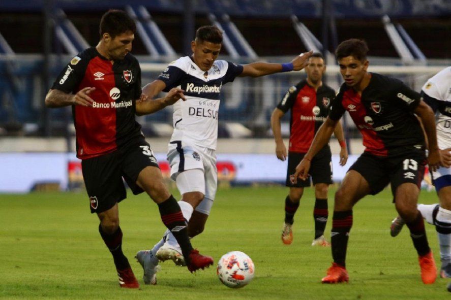 Eric Ramírez busca dominar la pelota en favor de Gimnasia ante la marca de varios jugadores de Newell´s