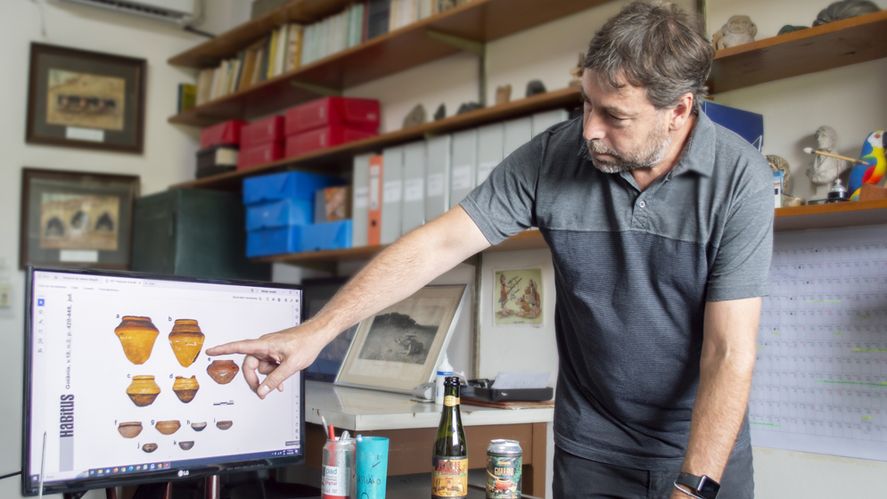 Bonomo señala imágenes de las tinajas utilizadas por los guaraníes para fermentar el maíz en la producción de cervezas.