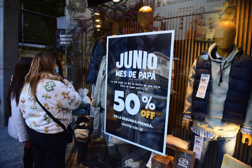 En el mes del padre, una mujer observa una oferta en la vidriera de un comercio