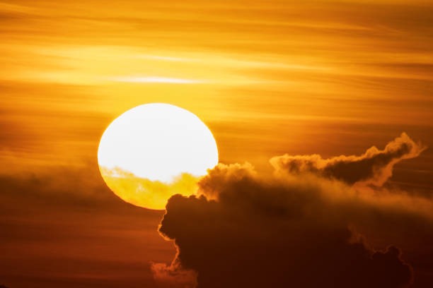 Atardecer durante el equinoccio de primavera con el sol y nubes doradas