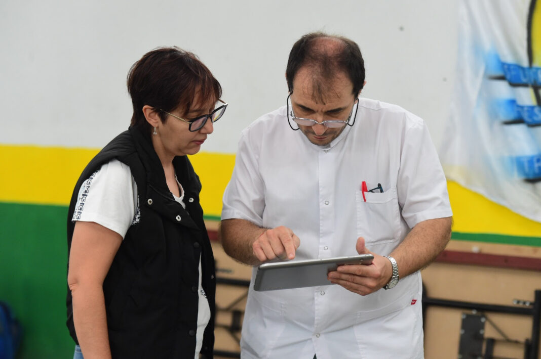Un médico y una mujer revisan datos en una tablet durante un operativo de salud en La Plata