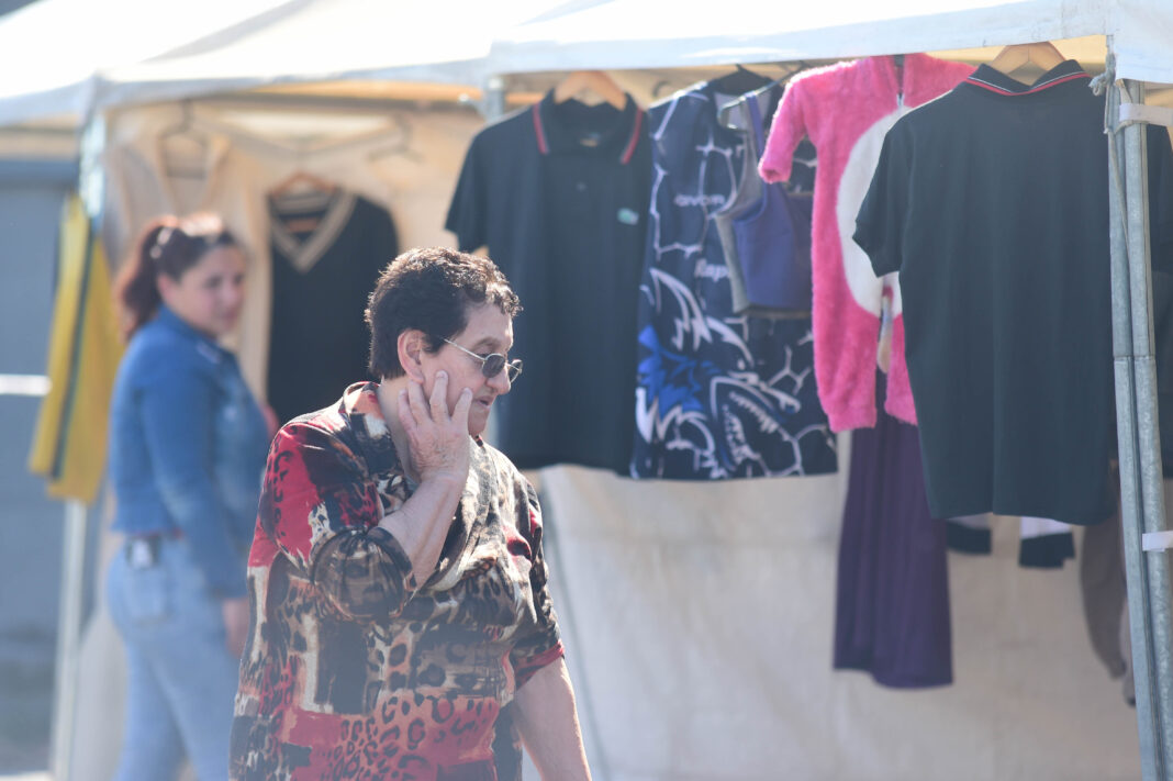 Vecina recorriendo los stands del Paseo de Compras del Sur II en Villa Elvira, con puestos de ropa de fondo