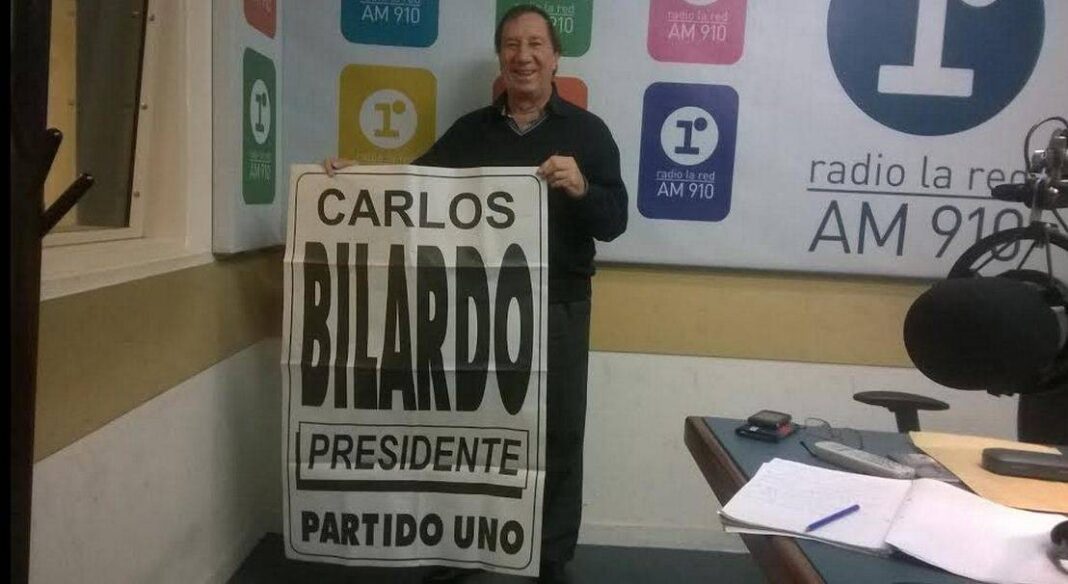 Carlos Bilardo posando con el cartel de su candidatura.