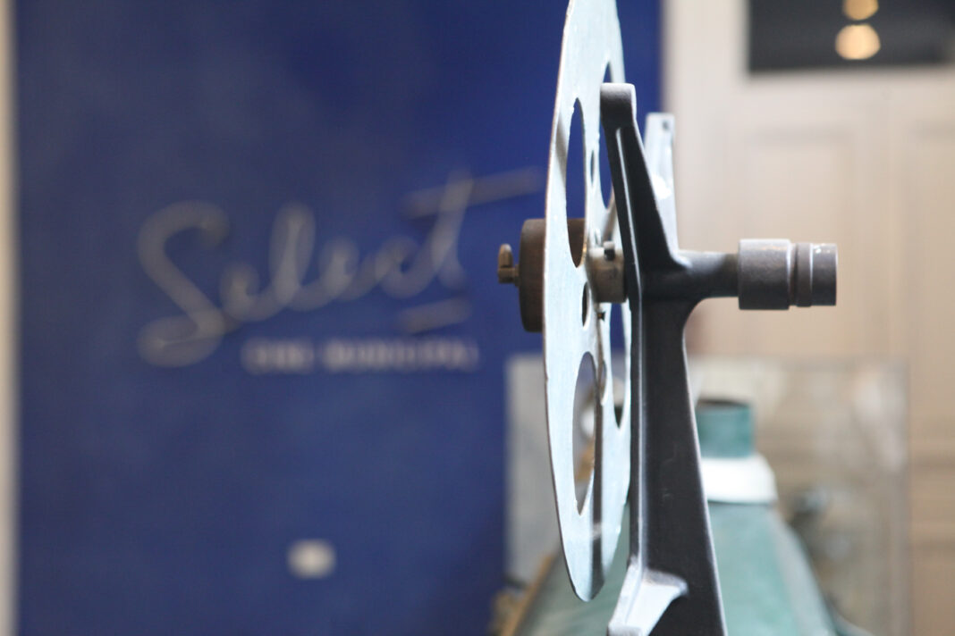 Primer plano del rollo de una película en un proyector, representando la cartelera de los cines municipales de La Plata.