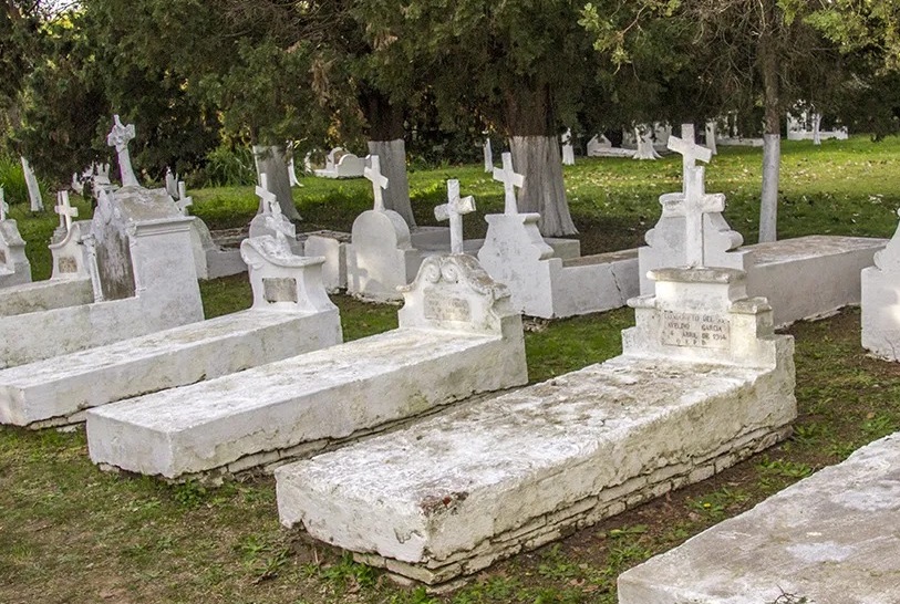 Cementerio de la Isla Martín García con sus características cruces torcidas, rodeado de árboles y misterio.