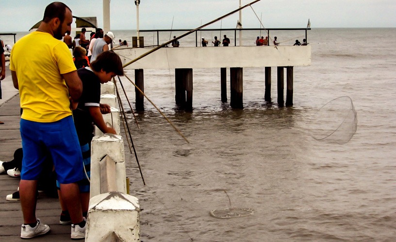 Fiesta de la Corvina Rubia en Mar de Ajó: pescadores en el muelle donde nació la tradición Pescadores lanzando sus cañas desde el muelle de Mar de Ajó, origen de la Fiesta Nacional de la Corvina Rubia.