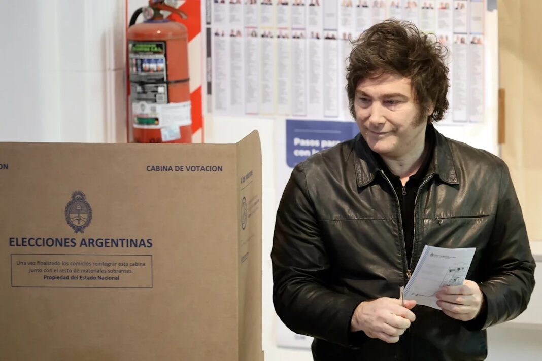 Milei y Karina Votan: Operativo y Silencio ante la Prensa Javier Milei junto a Karina Milei emitiendo su voto en un cuarto oscuro custodiado, sin contacto con la prensa.
