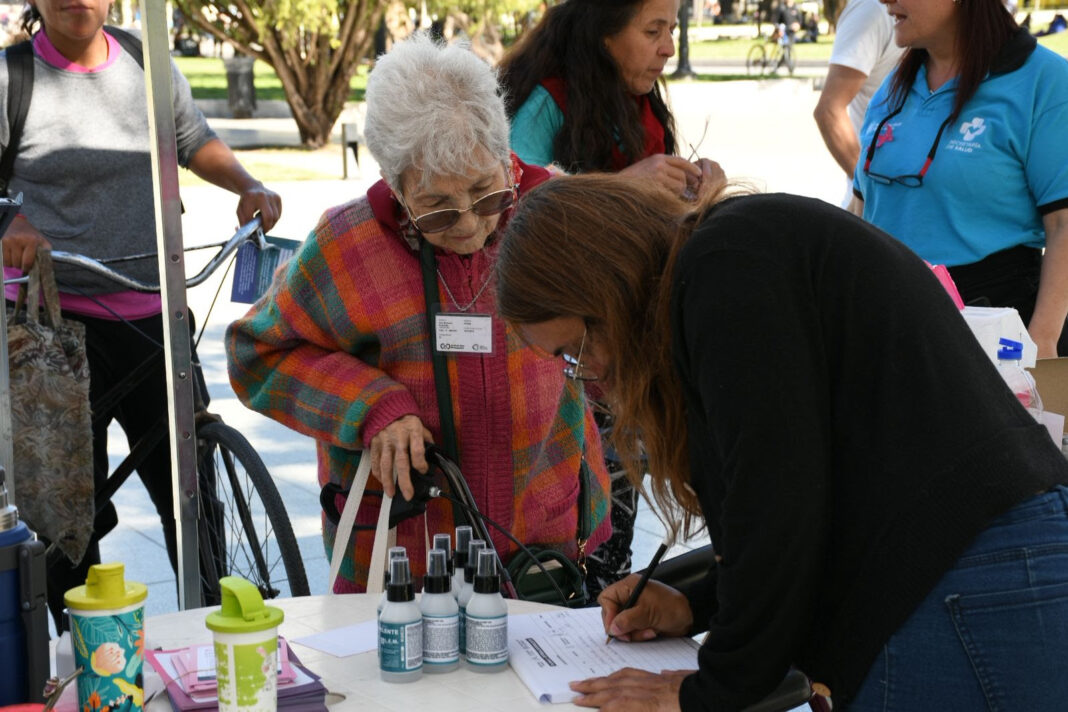 Adulta mayor recibe asistencia en jornada de campaña contra el dengue en La Plata.