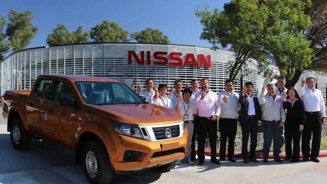Trabajadores de Nissan posan junto a una pick-up frente a la planta que cesará su producción en Argentina