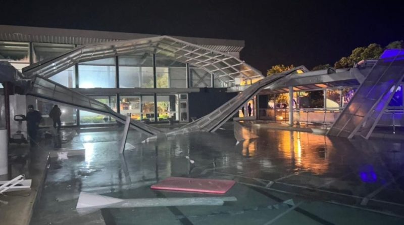 Estructura del techo o marquesina de un hospital en Benito Juárez colapsada tras el fuerte temporal, con escombros en el suelo mojado.