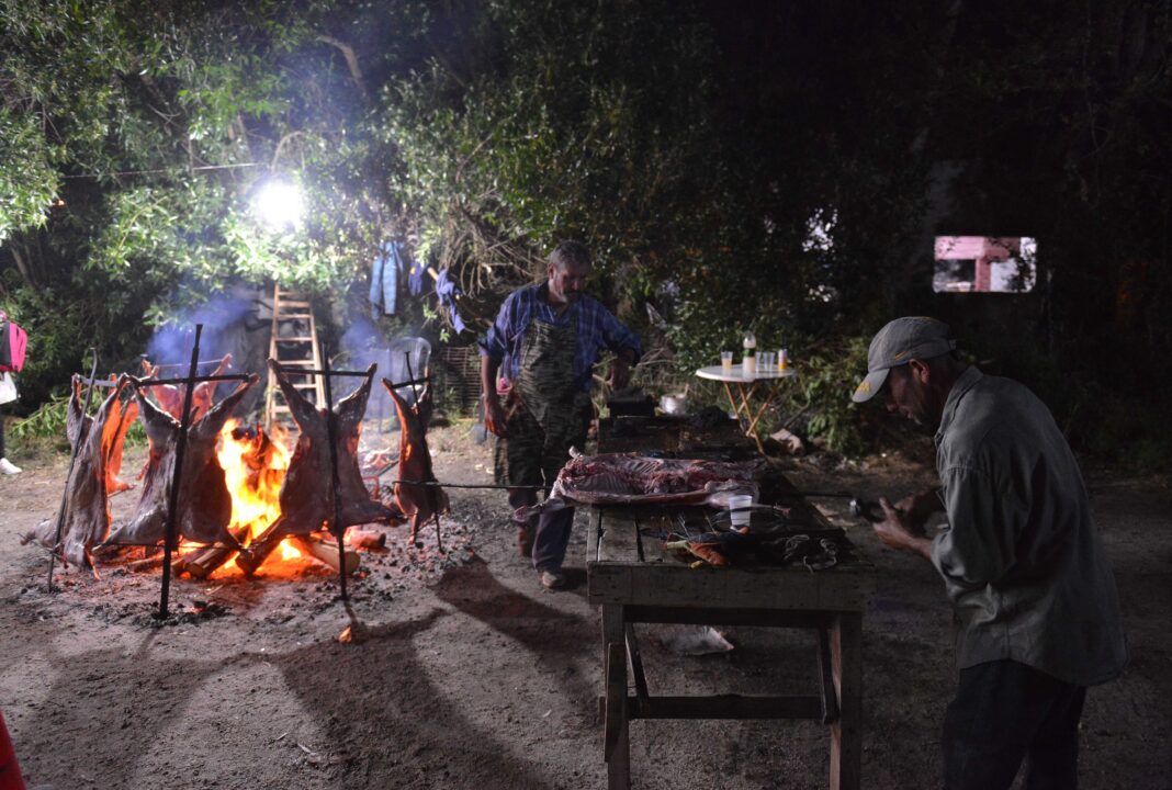 Asadores preparando corderos a la estaca durante la Fiesta del Cordero Costero en Mar de Cobo, provincia de Buenos Aires.