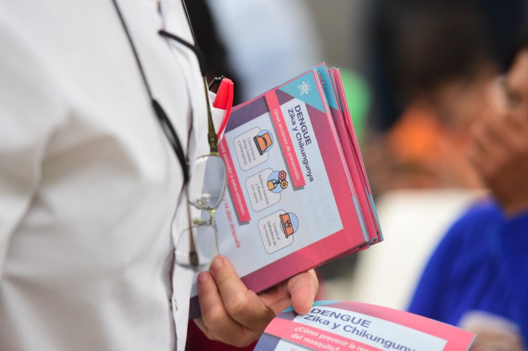 Profesional de la salud sosteniendo folletos informativos sobre la prevención de Dengue, Zika y Chikungunya, en el marco de las jornadas de salud comunitaria en La Plata.