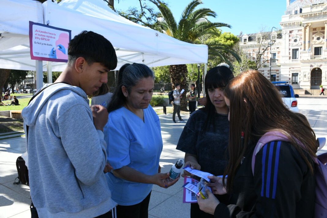 Equipo de salud realizando una campaña informativa al aire libre en La Plata, posiblemente sobre prevención de enfermedades transmitidas por vectores.