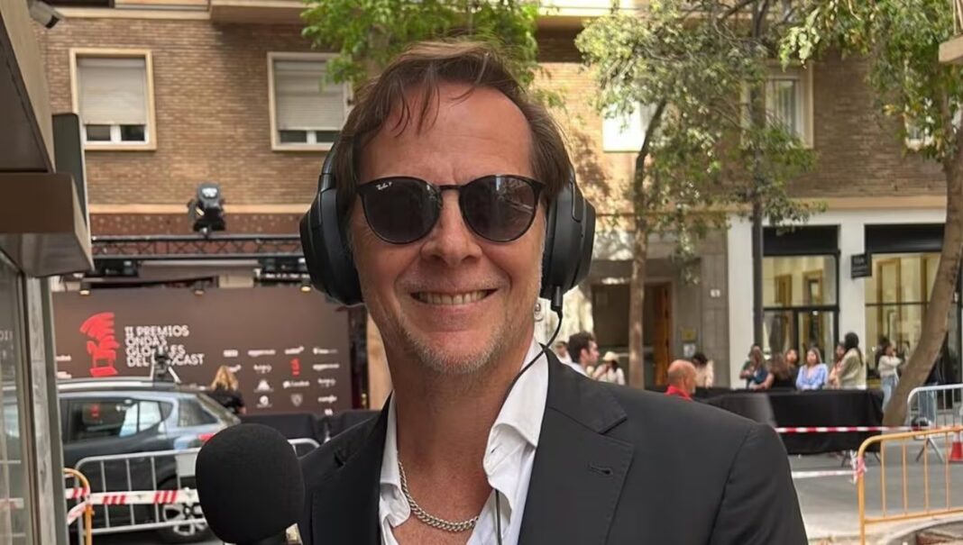 Matías Martin sonriendo con auriculares y micrófono, posiblemente en un evento de podcast, en el contexto de su aparición con una nueva pareja en el concierto de Oasis.