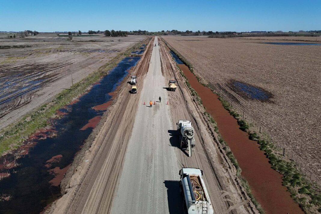 Maquinaria vial trabajando en un tramo en obra de la Ruta del Cereal, con campos cultivados a ambos lados.