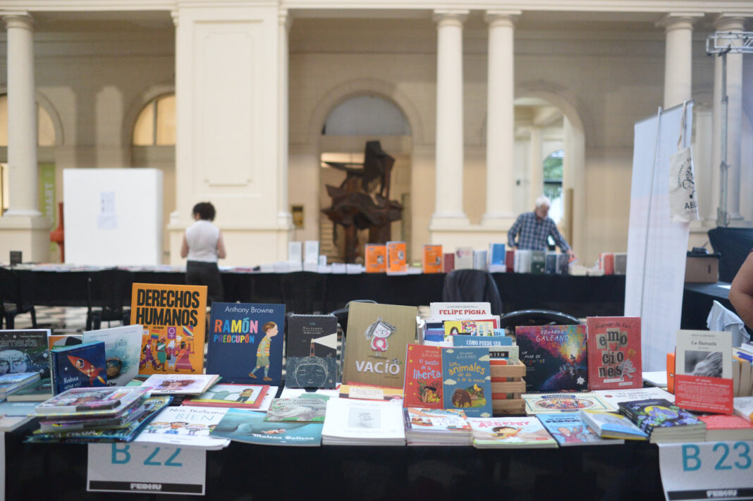 Primer plano de libros infantiles en una mesa de la Feria de Editores de Derechos Humanos en La Plata, ilustrando la agenda cultural del fin de semana.