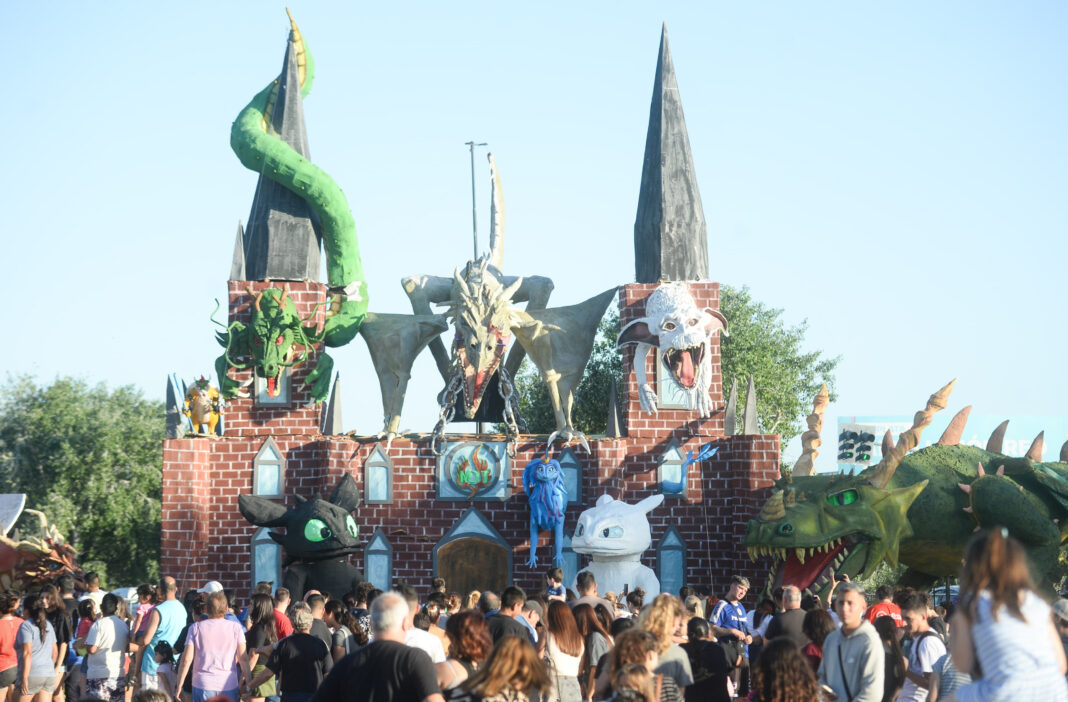 Multitud observando los grandes y coloridos muñecos de fantasía y dragones en La Plata, en el contexto de la apertura de inscripción para la quema de fin de año.