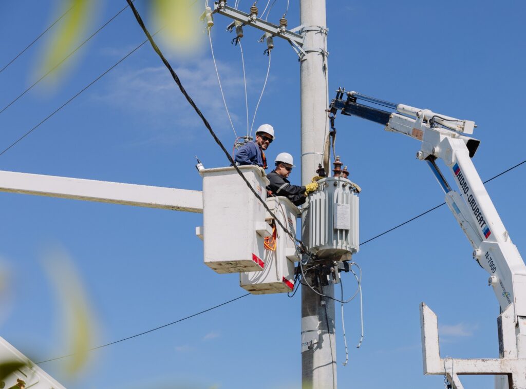 personal de edelap arregla un cable de baja tension subido a una grua