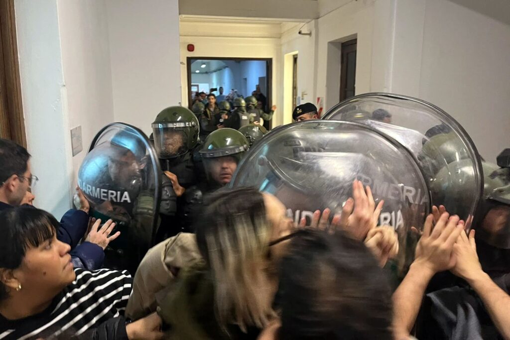 efectivos de gendarmeria empujan con escudos a trabajadores estatales dentro de la sede de la cnea