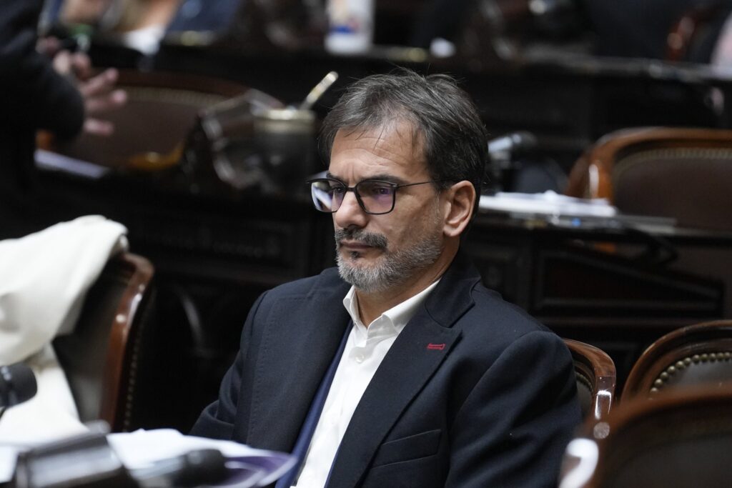 sebastian galmarini mirando serio hacia el horizonte desde su banca en la camara de diputados de la nacion